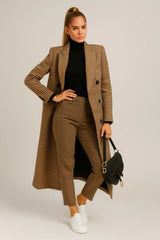 Elegant brown checked wool coat with tailored fit, styled with turtleneck and white sneakers.